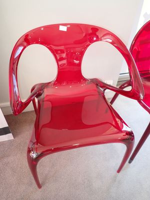 deux chaises en plastique rouges placées l'une à côté de l'autre dans une pièce