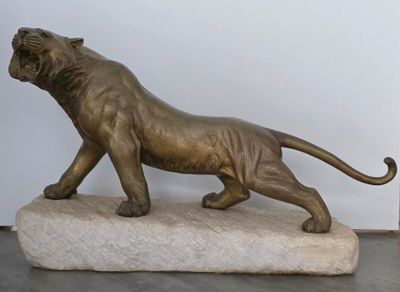 statue en bronze représentant un lion perché sur un rocher, dans une pièce