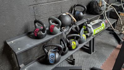 many kettle weights on a rack in a gym