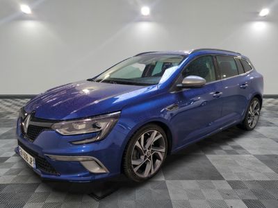 une voiture bleue garée sur le sol en damier d'un garage