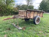 une petite charrette en bois qui est posée dans l'herbe