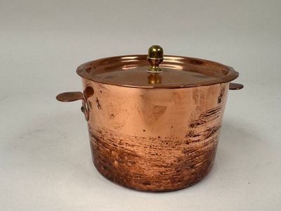 une image représentant une casserole en cuivre avec un couvercle, sur fond blanc