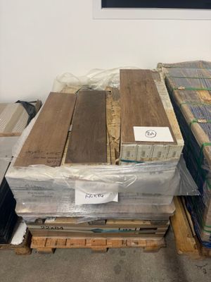 several stacks of wood planks stacked on pallets in a warehouse