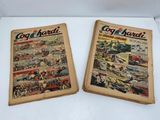 two old comic books sitting on top of a white table