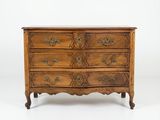 une commode ancienne dont les tiroirs sont ornés de sculptures élaborées