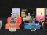 several bottles of perfume are lined up on a black surface