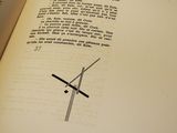 an open book with a drawing of a cross on it