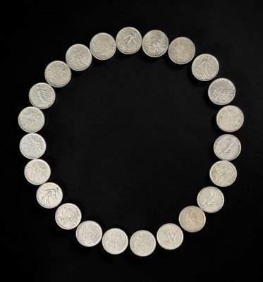 a close up of a necklace made of silver coins on a black background