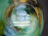 a close up of a green vase with a reflection in it