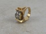 a close up of a gold and diamond ring on a table