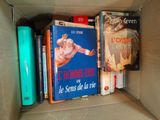 many books in a cardboard box on the shelf