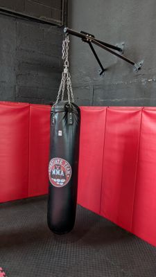 a man standing next to a punching bag in a gym