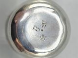 an antique silver plate with a silver handle on a white surface