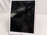 an ipad with a cracked screen sitting on top of a table