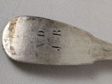 a silver spoon with a silver handle on a white surface