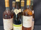 Plusieurs bouteilles de vin sont alignées sur un fond noir