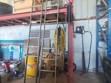 une photo d'un garage avec une échelle et un espace de travail