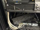 a rack of computer equipment with a keyboard, mouse, and other electronics