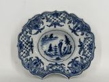 assiette bleue et blanche représentant un homme et une femme dans un bateau