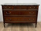 une commode en bois avec un plateau en marbre dans une pièce