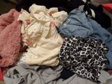 a pile of clothes in a suitcase on the floor