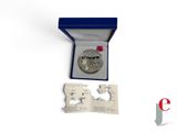 a silver coin in a blue box with a red ribbon around it