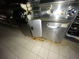 a dirty stove and oven in a kitchen with dirty flooring