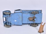 a blue toy train car with a wooden handle next to a piece of wood