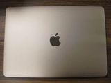 un ordinateur portable Apple posé sur une table en bois
