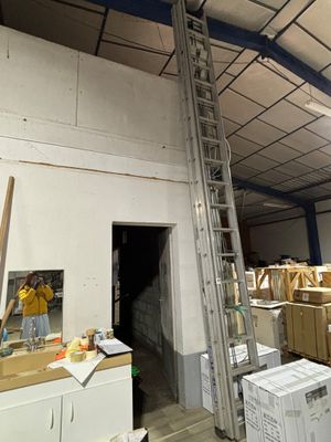un homme qui se tient sur une échelle dans un bâtiment