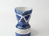 a blue and white vase sitting on a white surface