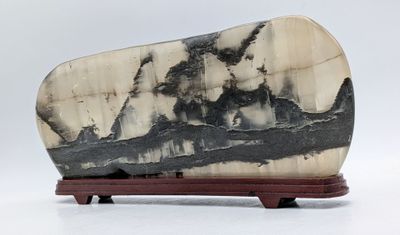 une photo représentant une dalle de marbre noir et blanc posée sur un socle en bois