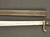 an old knife is laying on a table next to a knife