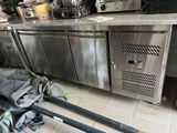 a large stainless steel kitchen with a bunch of bags on the floor