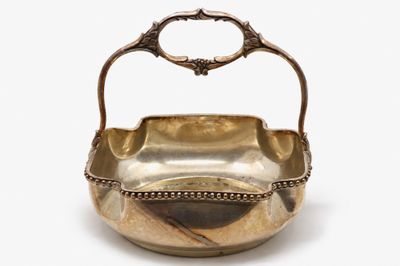 silver plated bowl with handle and handles on a white background