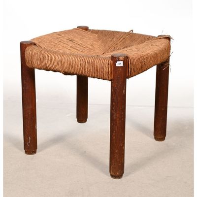 un petit tabouret en bois avec une assise tressée