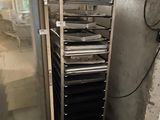 une photo d'une pièce avec un réfrigérateur et une étagère remplie de casseroles