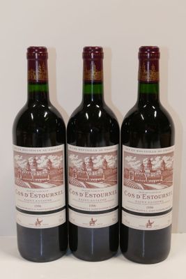 trois bouteilles de vin rouge sont alignées sur une table
