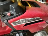 a red lawn mower that is parked in a garage