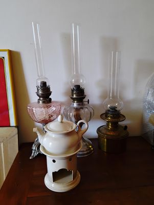 une petite table sur laquelle se trouvent une théière, une bougie et d'autres objets