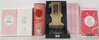 trois boîtes de parfums et une horloge posées sur une table