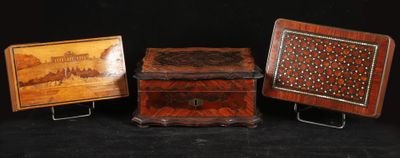 three small wooden boxes with designs on them on a black background