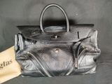 an image of a black leather purse with a tag on it