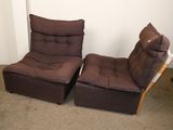 une paire de chaises marron dans une pièce avec de la moquette et des murs blancs