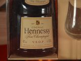 a bottle of hennessy fine champagne next to a glass of wine