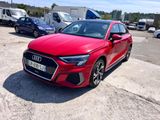the red audi is parked in a parking lot with other cars
