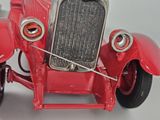 a red toy car that is sitting on a table