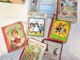 de nombreux livres pour enfants posés par terre à côté d'une boîte