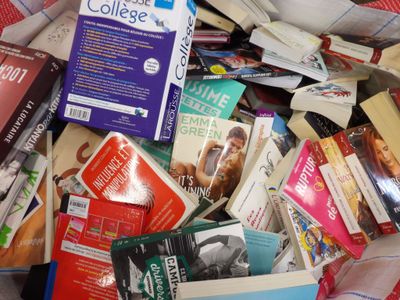 a pile of books sitting on top of a bed