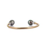 a close up of a bracelet with two pearls on it